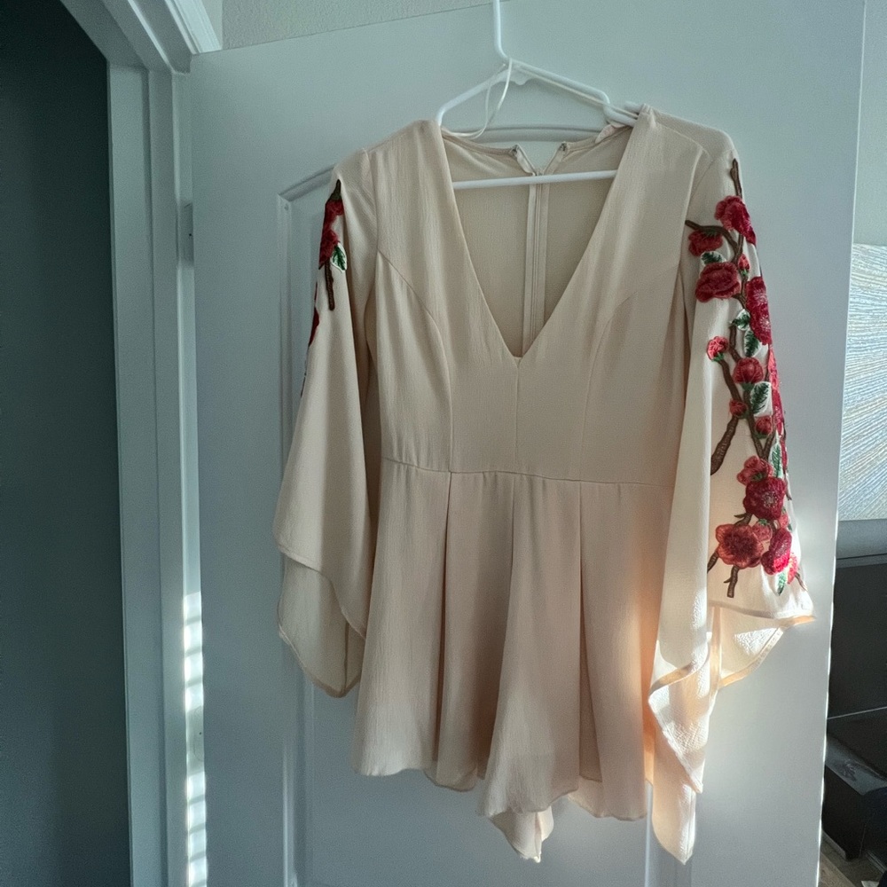 Small cream romper with floral embellishment